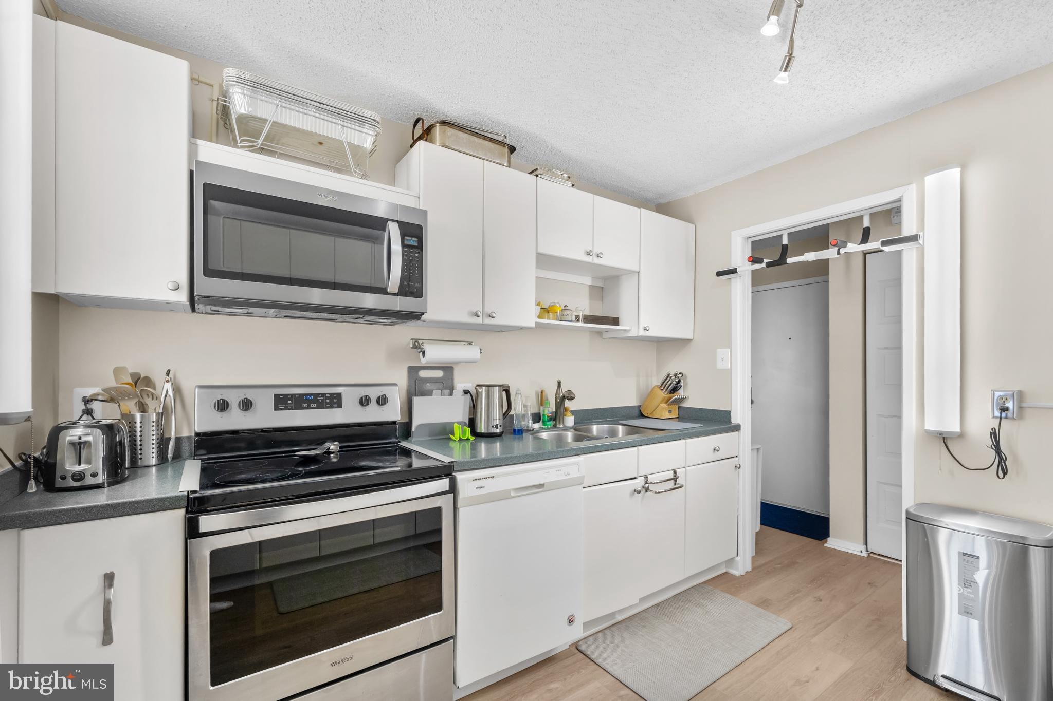2300 Pimmit Drive, Unit 807 Falls Church, VA 22043 - Photo 16 of 33 a kitchen with stainless steel appliances a stove a sink a refrigerator a microwave and cabinets