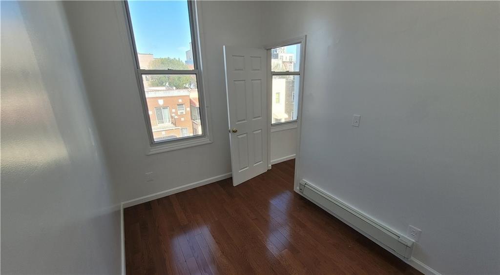 680 Hart Street Brooklyn, NY 11221 - Photo 2 of 8 an empty room with wooden floor and windows