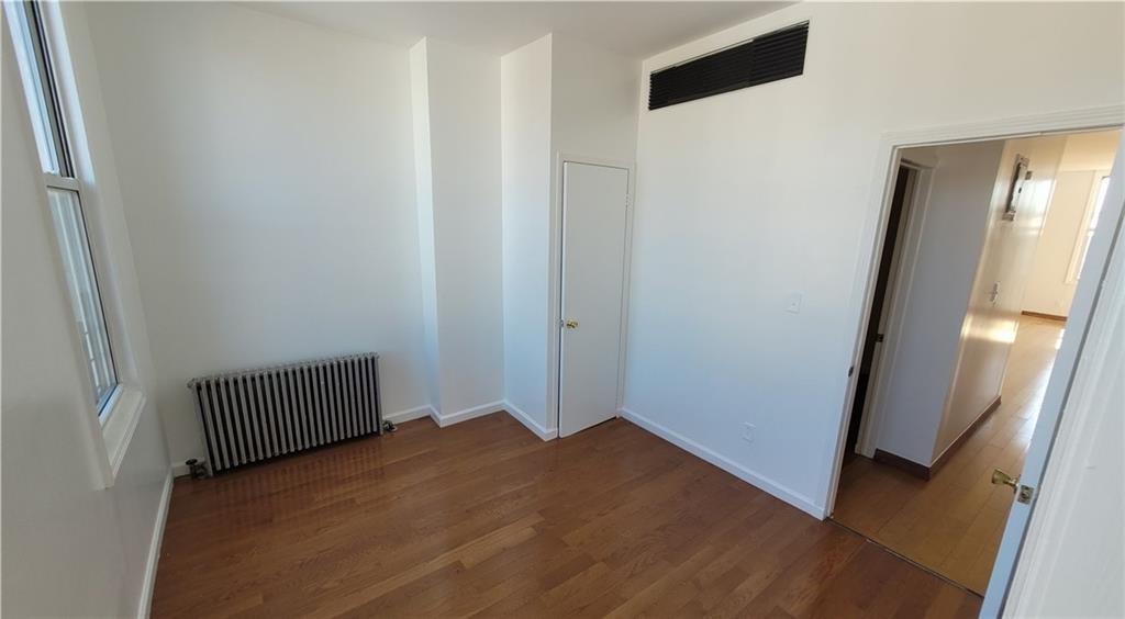 680 Hart Street Brooklyn, NY 11221 - Photo 3 of 8 an empty room with wooden floor and windows