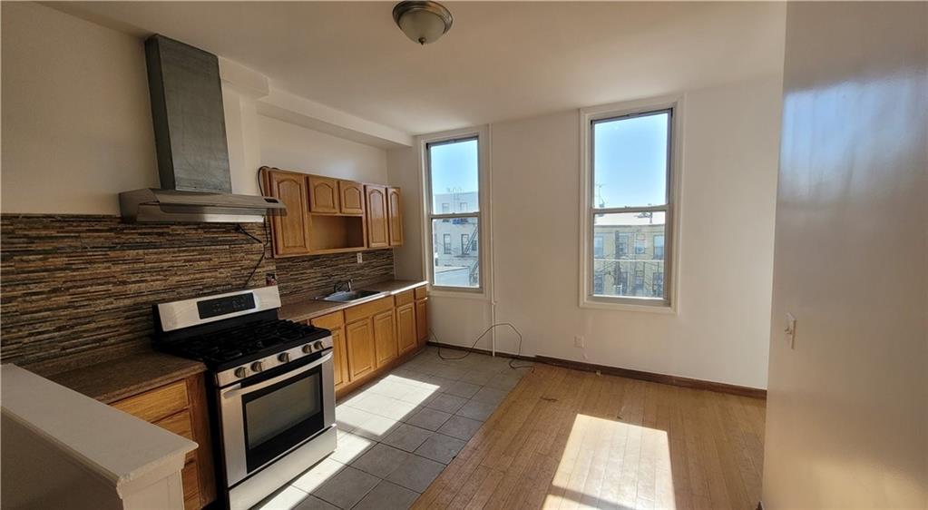 680 Hart Street Brooklyn, NY 11221 - Photo 6 of 8 a kitchen with stainless steel appliances kitchen island granite countertop a stove and a sink