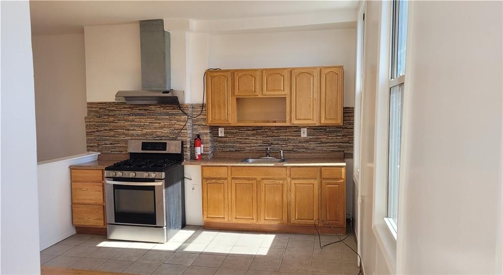 680 Hart Street Brooklyn, NY 11221 - Photo 8 of 8 a kitchen with stainless steel appliances granite countertop a stove and a refrigerator