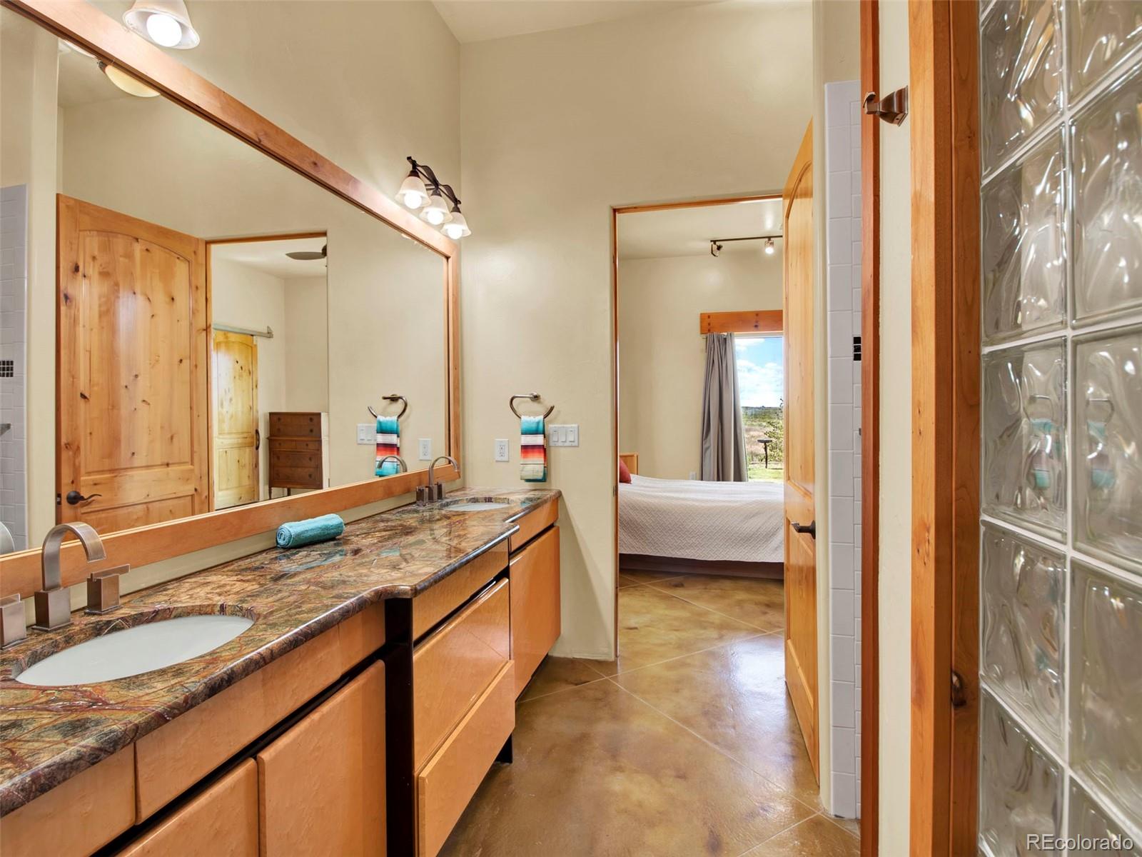 5549 Yulle Road Bennett, CO 80102 - Photo 30 of 47 a en suite bathroom with a granite countertop sink and a mirror