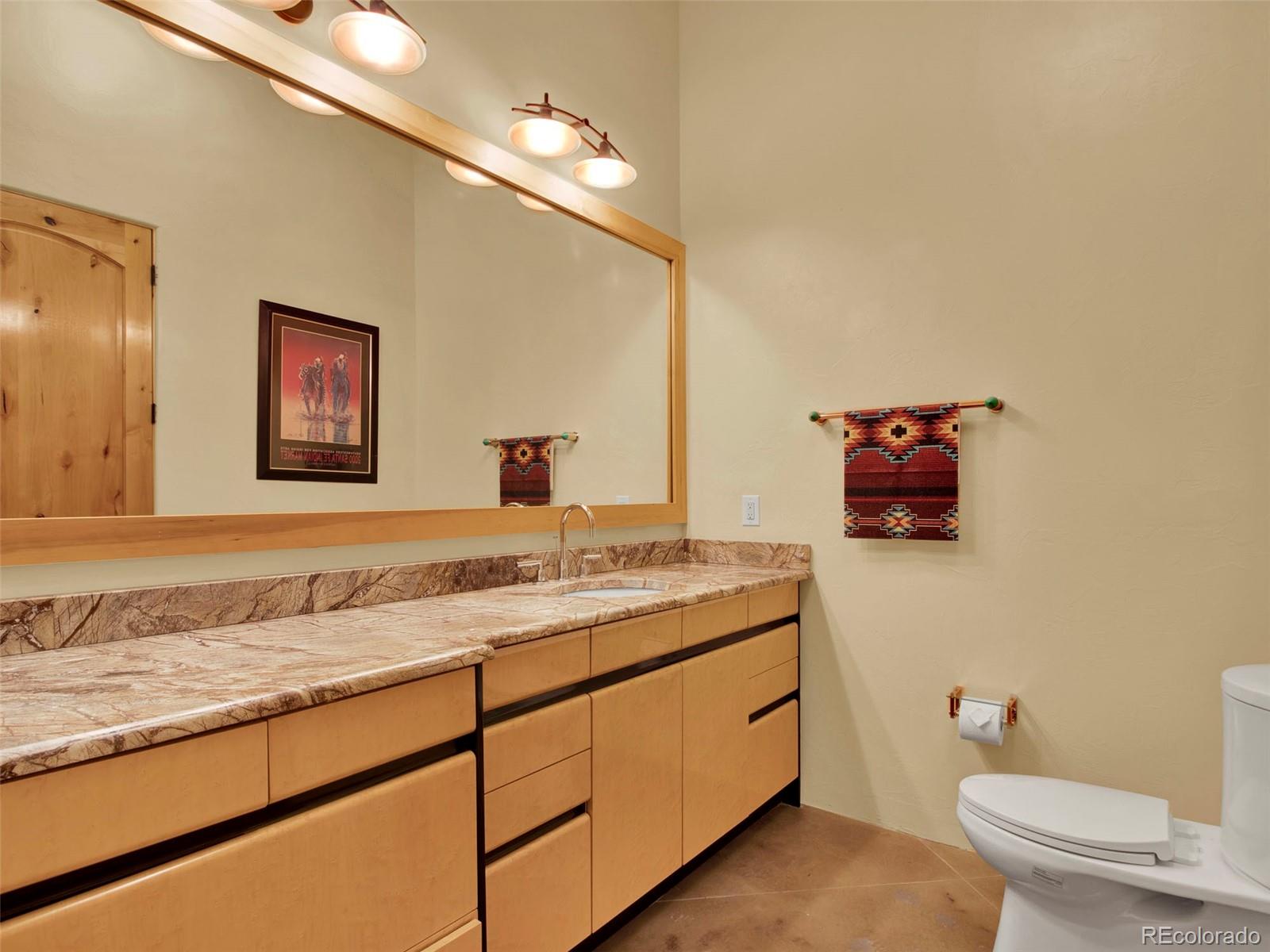 5549 Yulle Road Bennett, CO 80102 - Photo 42 of 47 a bathroom with a granite countertop sink and a mirror with toilet