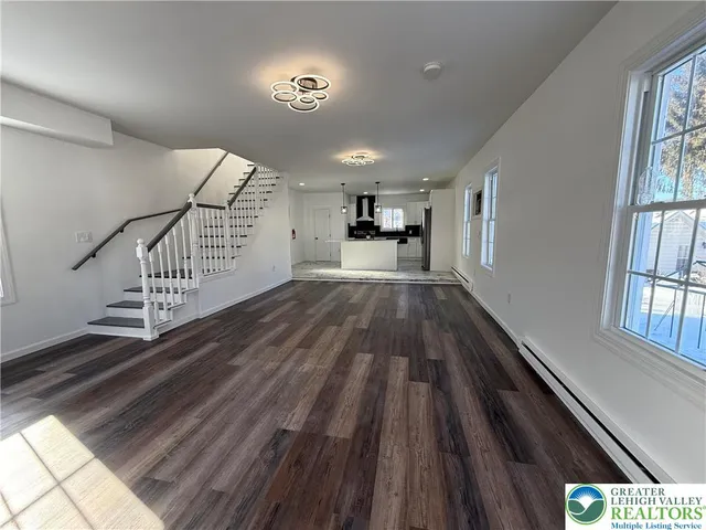 a view of a hallway with wooden floor and staircase