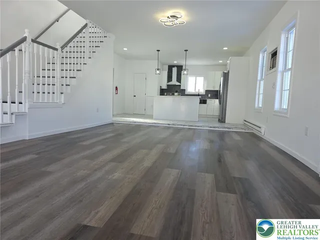a view of kitchen with granite countertop kitchen island wooden floors and stainless steel appliances