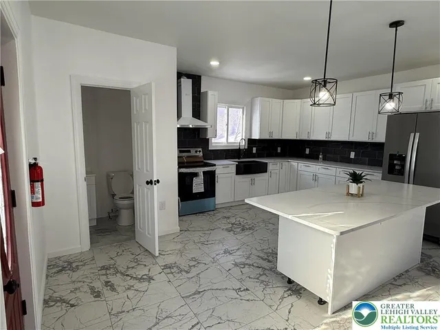 a kitchen with a sink a counter top space appliances and cabinets