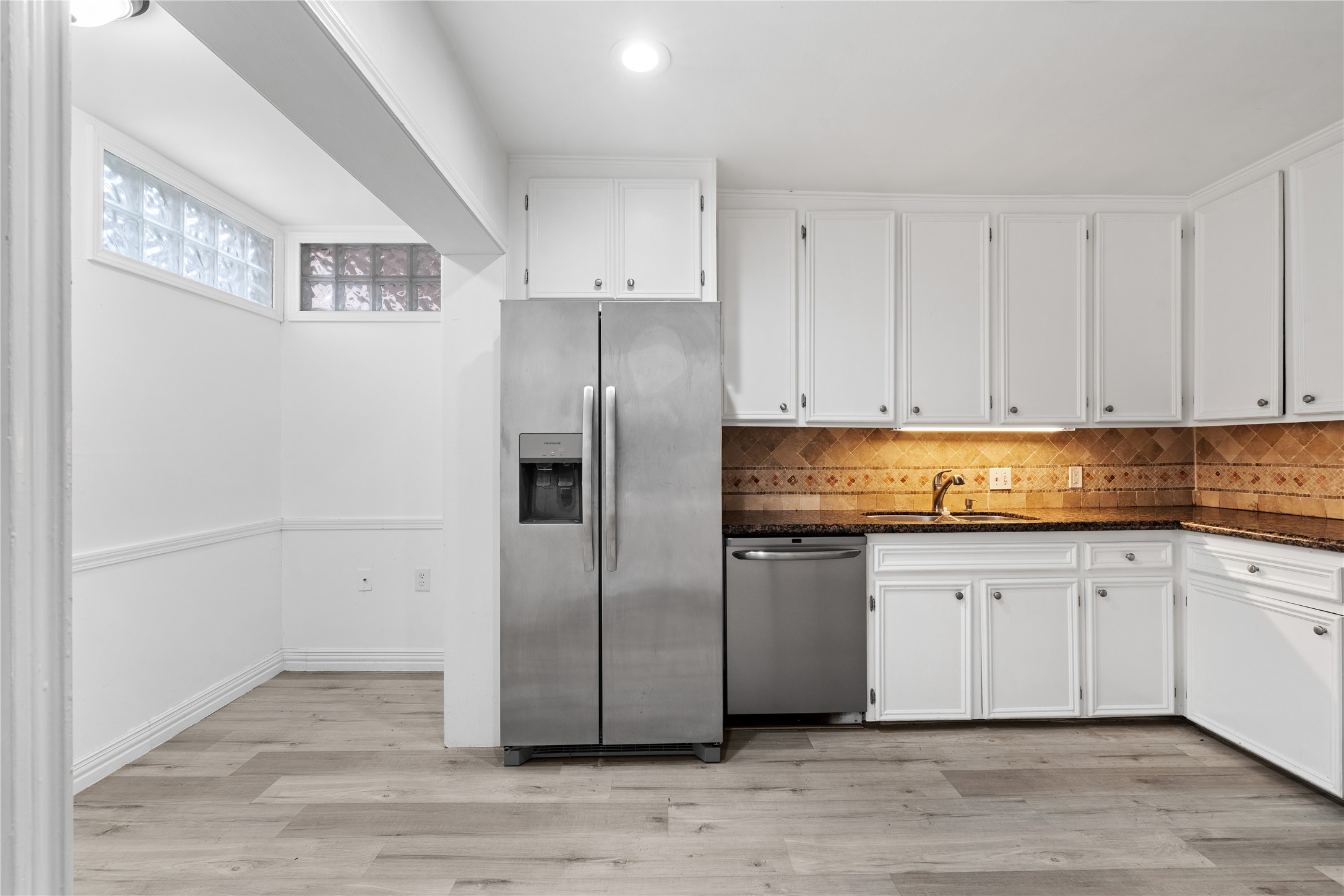6303 Crab Orchard Road, Unit 3 Houston, TX 77057 - Photo 12 of 30 This kitchen isn't just about looks—it’s about lifestyle. To the left, a bright breakfast nook or pantry area features unique glass block windows, flooding the workspace with soft, natural light while maintaining complete privacy.