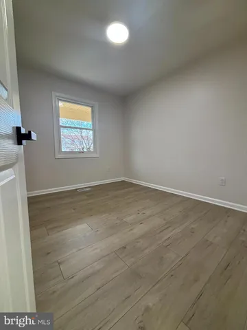 an empty room with wooden floor and door