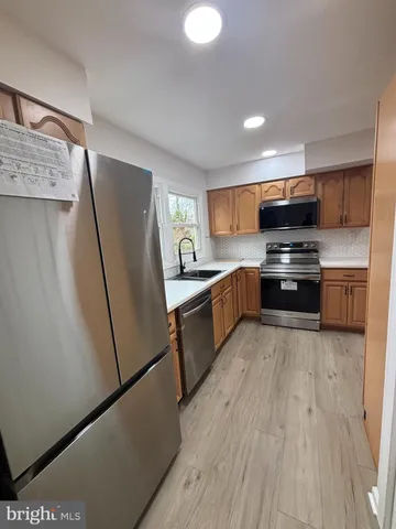 a kitchen with stainless steel appliances granite countertop a refrigerator a stove top oven a sink and dishwasher