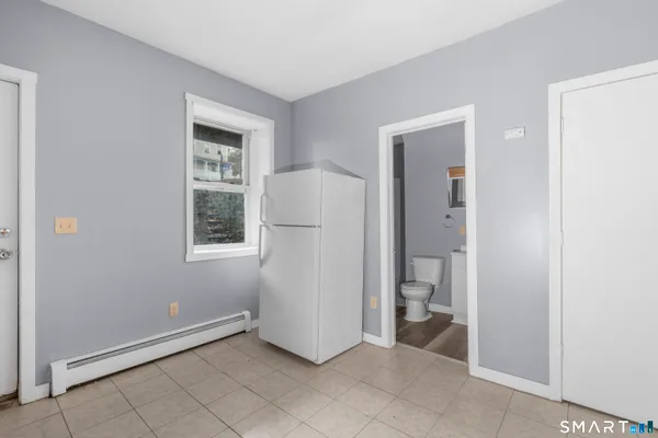 a view of an empty room with bathroom and a window