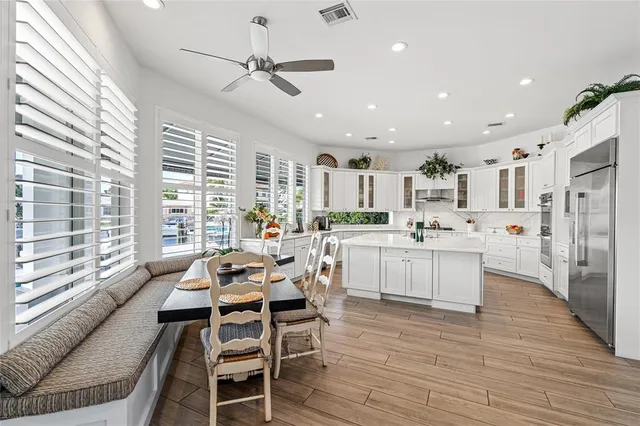 a kitchen with a table chairs refrigerator and cabinets