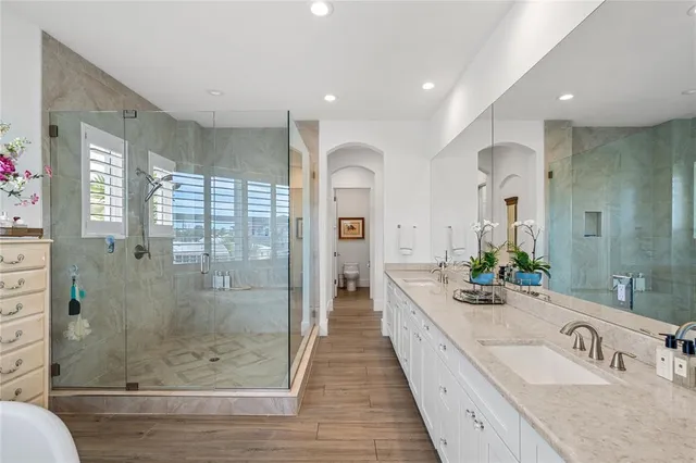a large bathroom with a granite countertop sink a large mirror a shower and bathtub