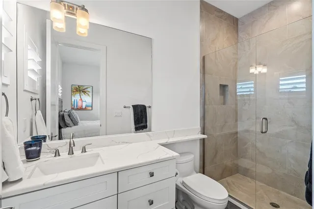 a bathroom with a sink a toilet and shower