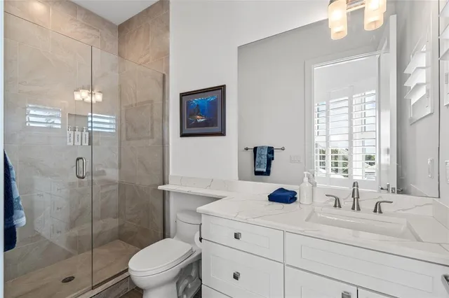 a bathroom with a sink a toilet a window and shower