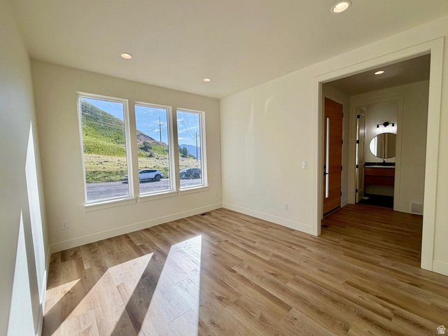 905 Settlement Canyon Road Tooele, UT 84074 - Photo 8 of 12 Room featuring wood-finish flooring, recessed lighting, and a trio of tall windows providing abundant natural light