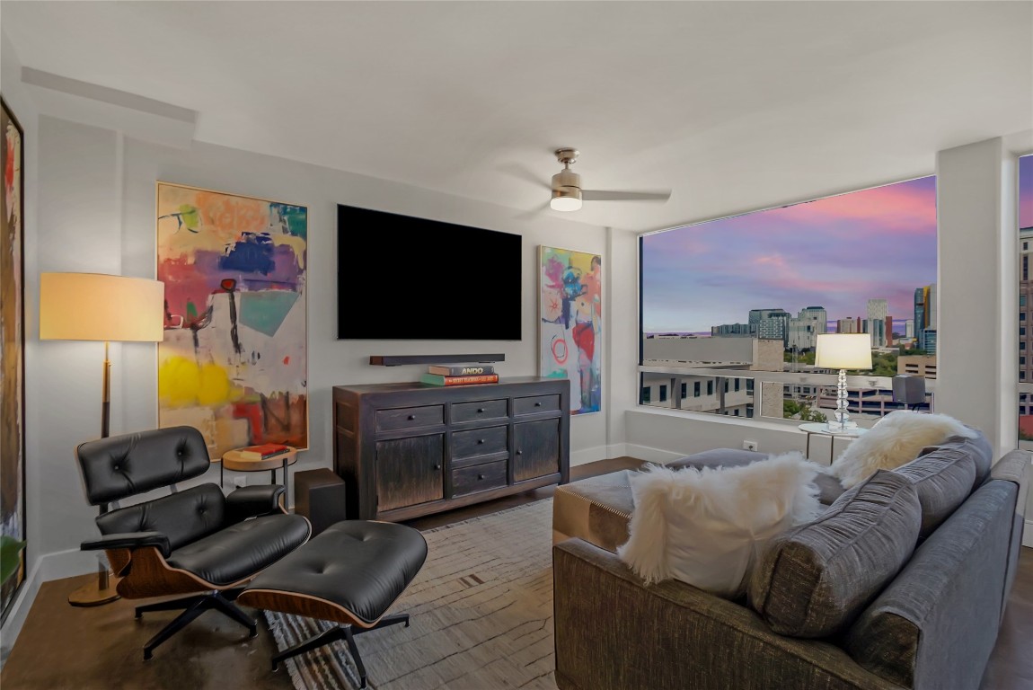 Living area with ceiling fan and baseboards