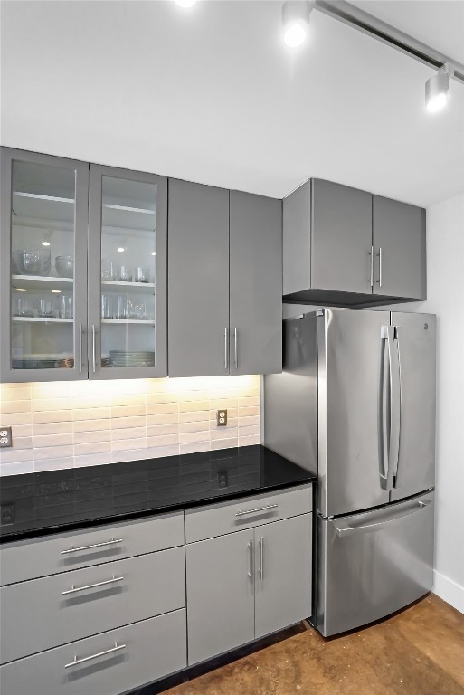 1212 Guadalupe Street, Unit 1004 Austin, TX 78701 - Photo 17 of 33 Kitchen with gray cabinetry, freestanding refrigerator, glass insert cabinets, rail lighting, and modern cabinets