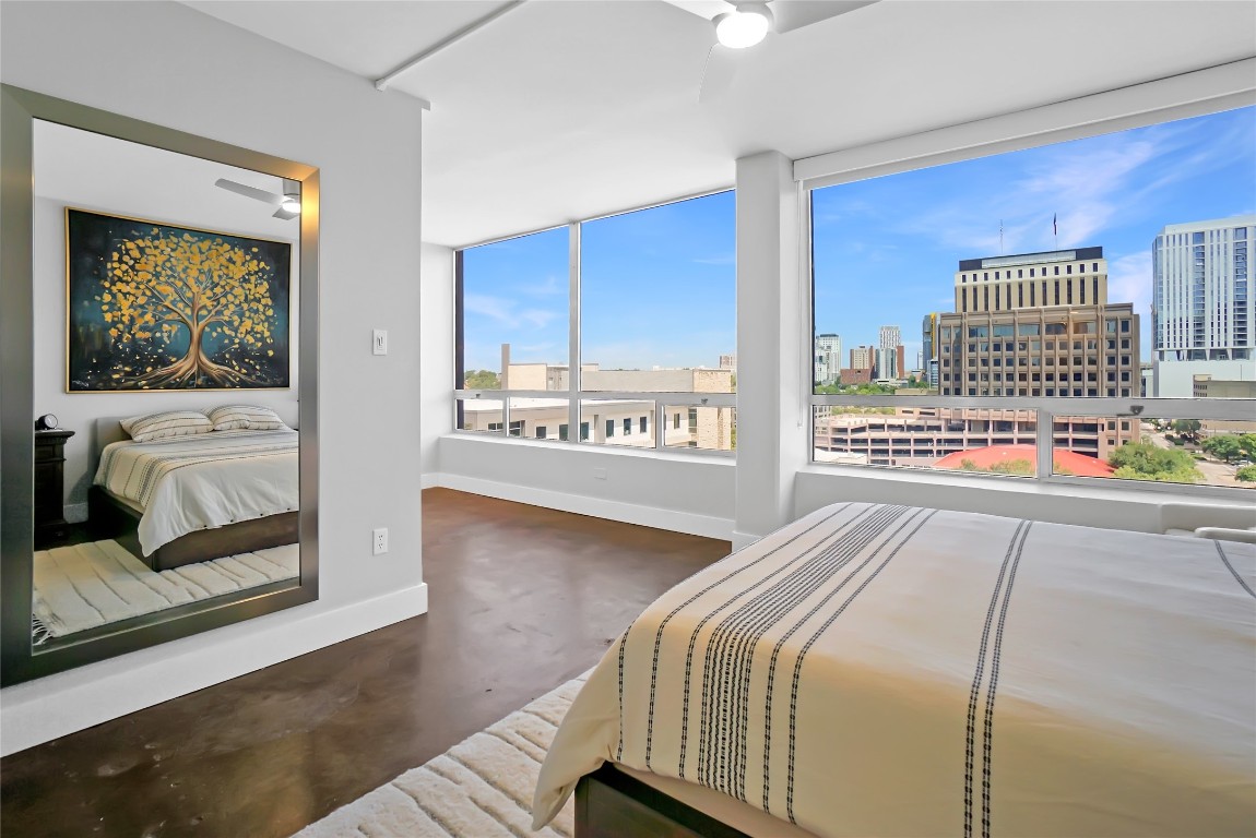 1212 Guadalupe Street, Unit 1004 Austin, TX 78701 - Photo 21 of 33 Bedroom featuring a ceiling fan, finished concrete floors, and a view of city