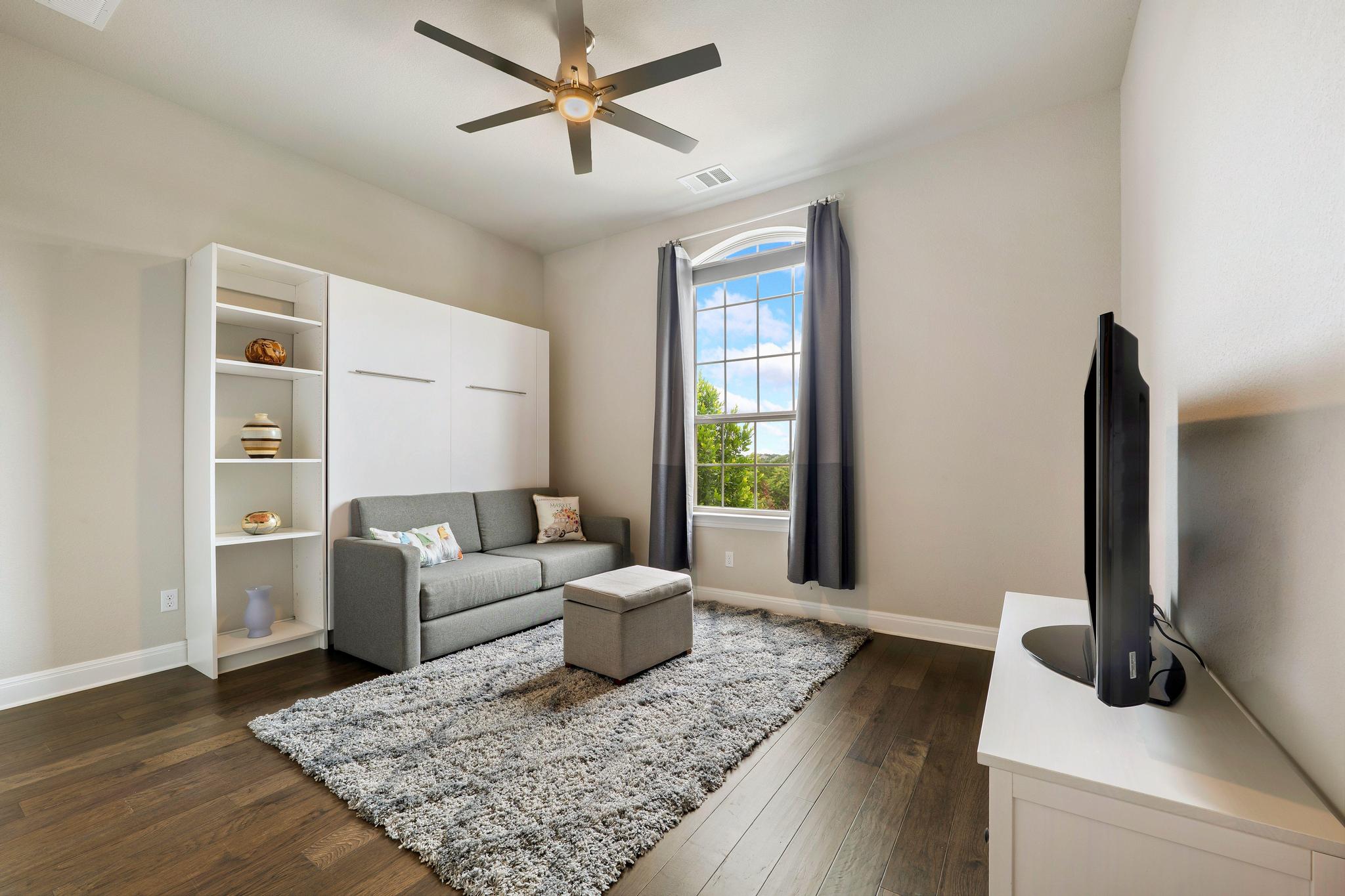1009 Legacy Crossing Georgetown, TX 78628 - Photo 7 of 40 Rich hardwood flooring complements a built-in wall unit, providing both storage and sleeping accommodations.