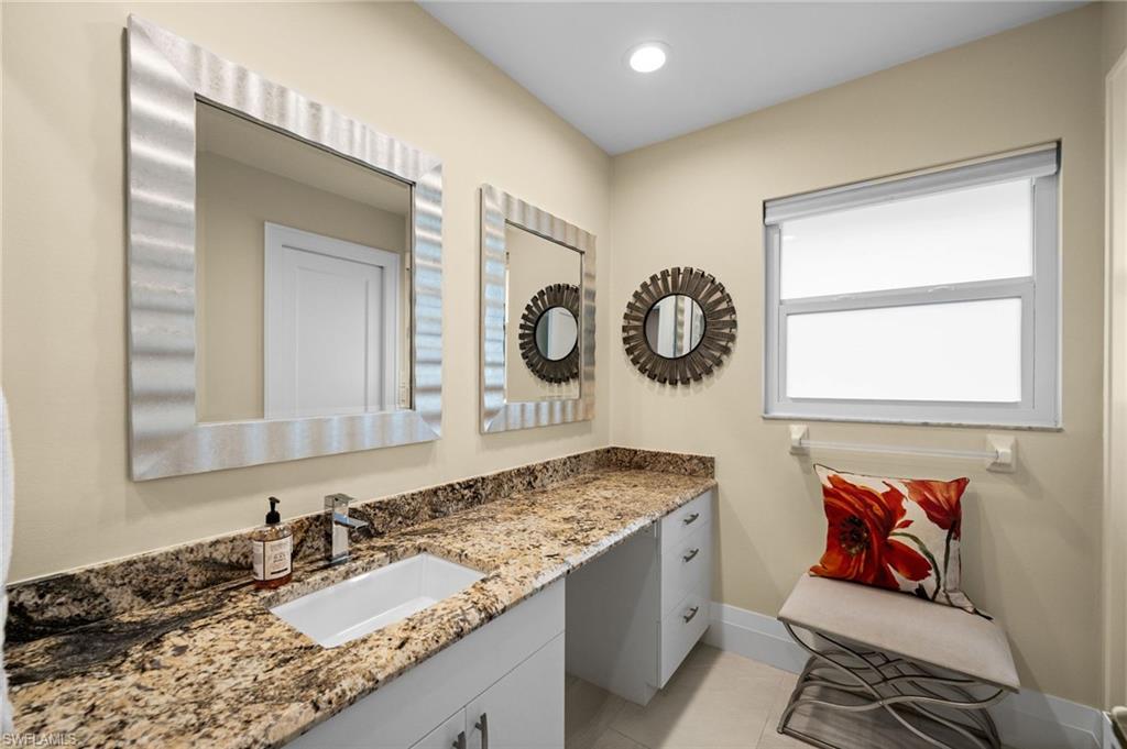 2022 Duke Drive Naples, FL 34110 - Photo 22 of 40 a bathroom with a granite countertop double vanity sink and a mirror