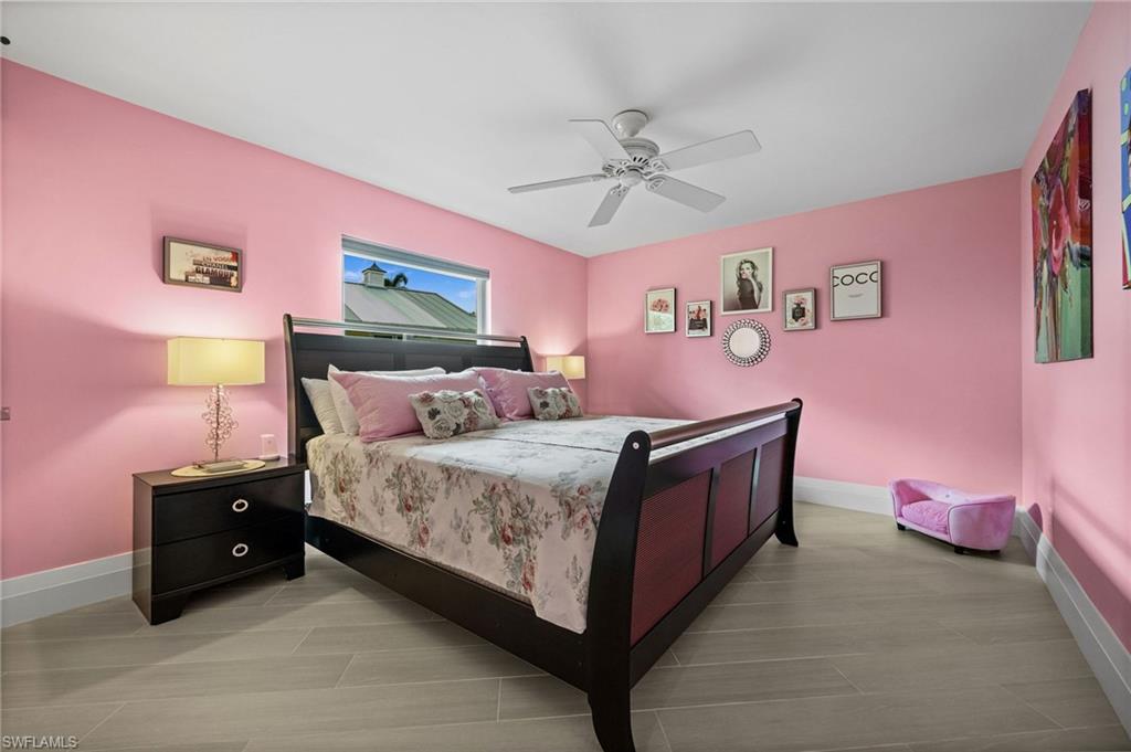 2022 Duke Drive Naples, FL 34110 - Photo 23 of 40 a spacious bedroom with a bed and a chandelier
