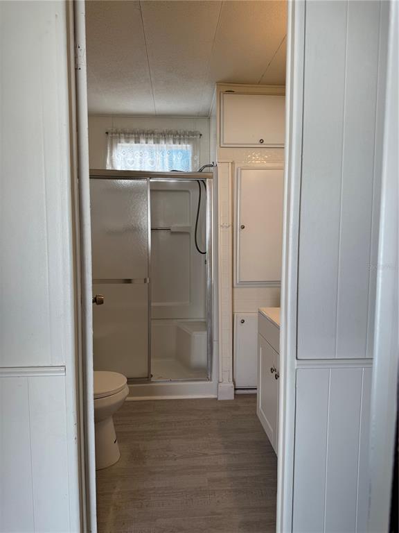 10805 Tioga Drive Port Richey, FL 34668 - Photo 11 of 15 a bathroom with a glass shower door and a toilet