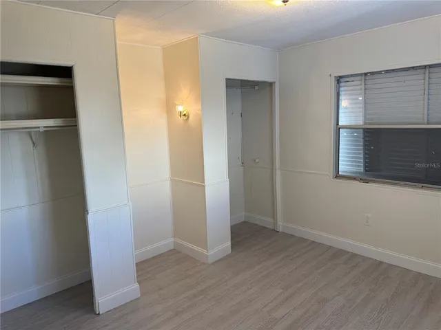 an empty room with wooden floor and closet
