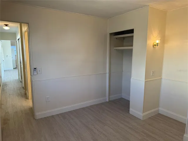 an empty room with wooden floor and closet