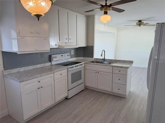 a kitchen with white cabinets and white appliances