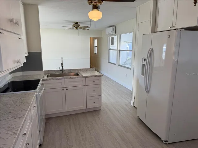 a kitchen with a refrigerator sink and cabinets