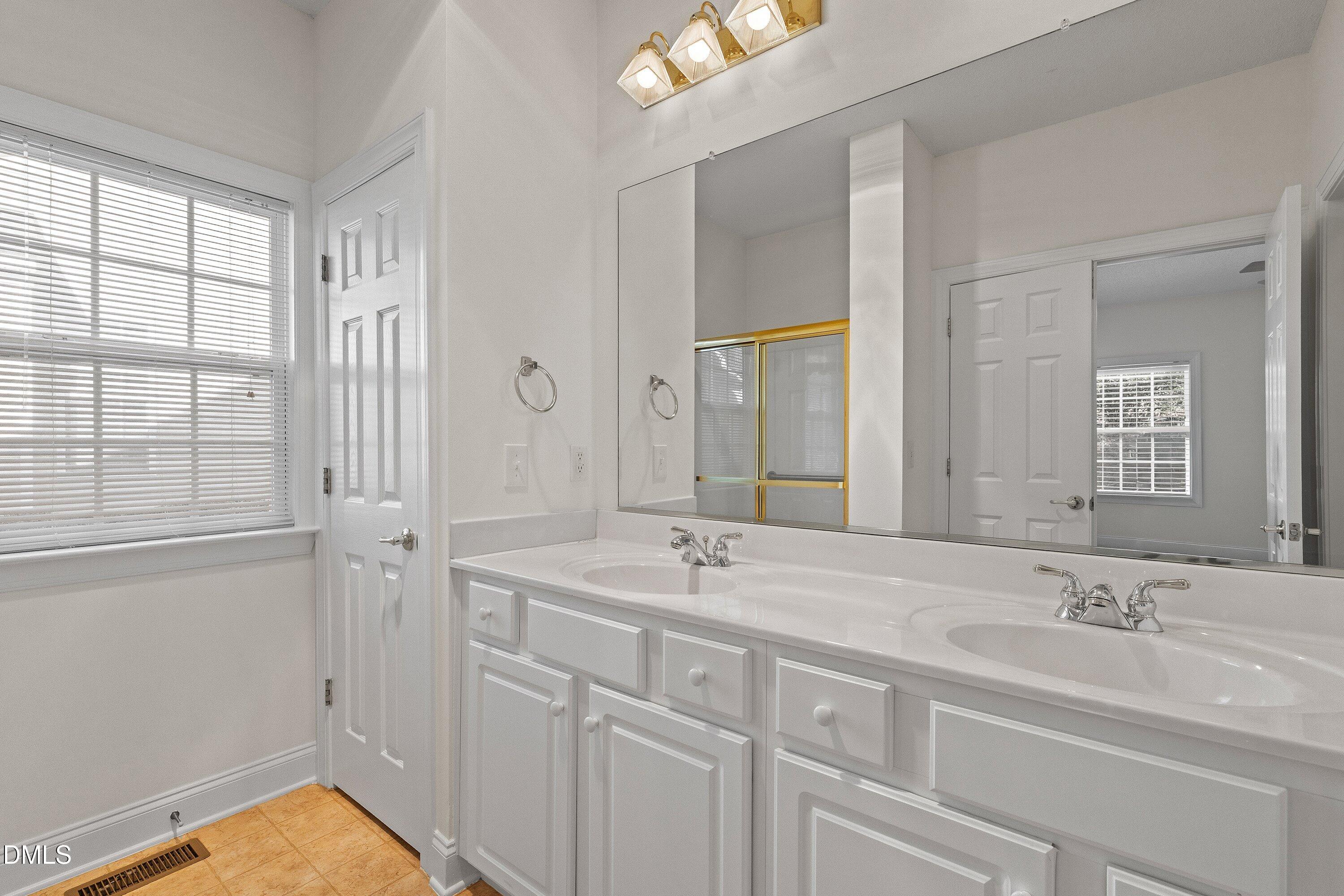 105 Rockport Ridge Way Cary, NC 27519 - Photo 33 of 43 a bathroom with double vanity sink a mirror and a shower