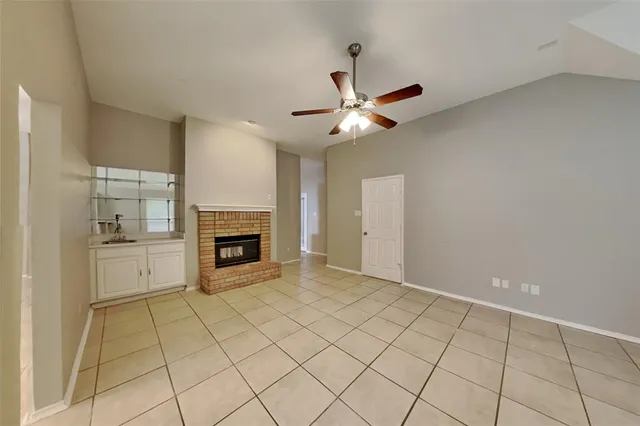 a view of an empty room with a fireplace and a window