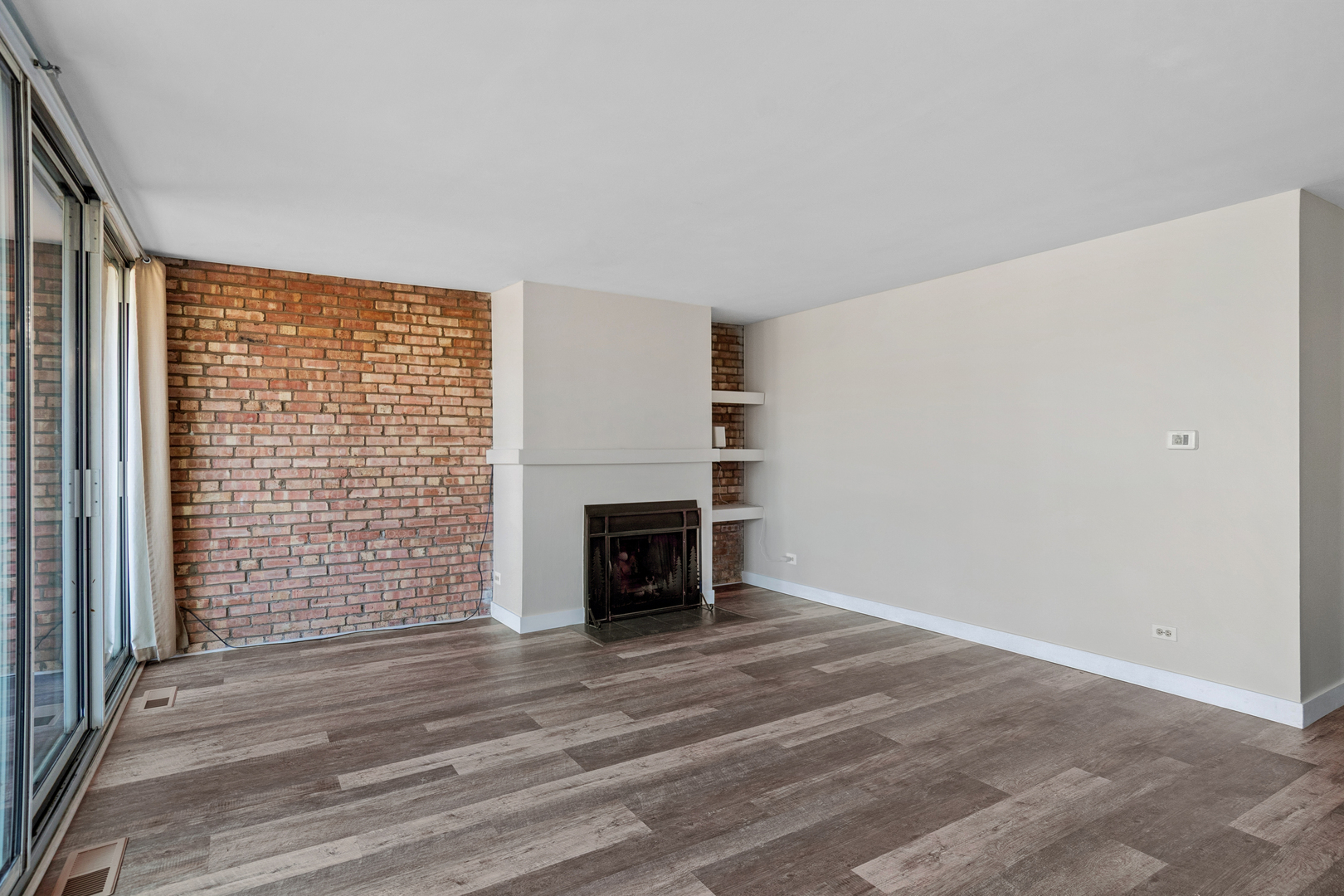 6012 Forest View Road, Unit 1D Lisle, IL 60532 - Photo 14 of 21 a view of an empty room with a fireplace and a window