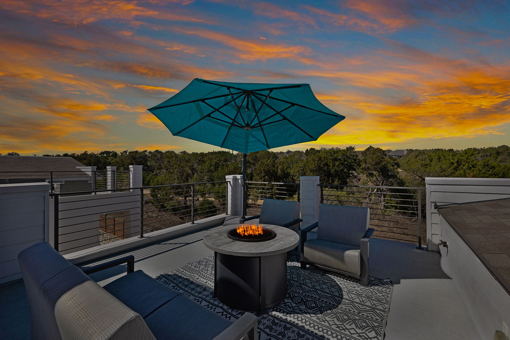 5214 Pink Poppy Pass Austin, TX 78735 - Photo 2 of 34 Patio terrace at dusk with a patio area, an outdoor living space with a fire pit, and a view of trees