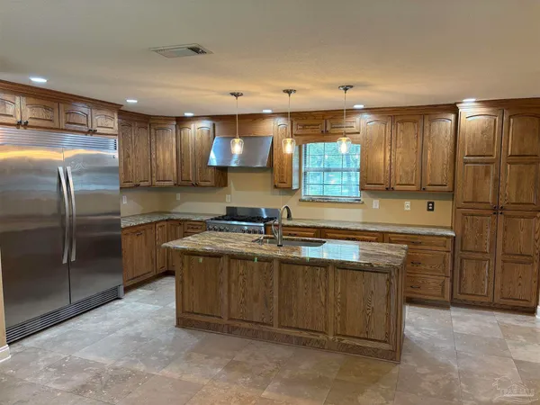 a kitchen with stainless steel appliances granite countertop a sink stove and refrigerator