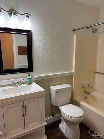 a bathroom with a toilet sink and mirror