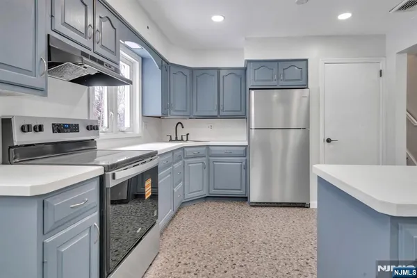 a kitchen with a sink a stove a refrigerator and a cabinets
