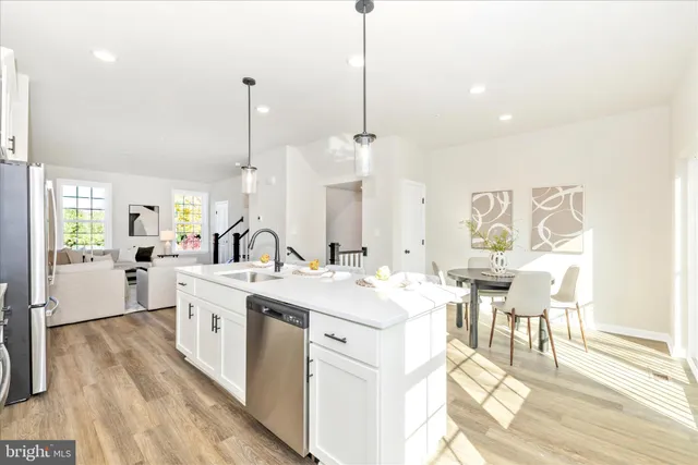 a large kitchen with kitchen island a sink a stove a dining table and chairs