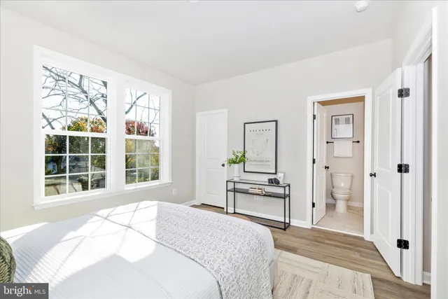 a bedroom with a bed and a window with chair