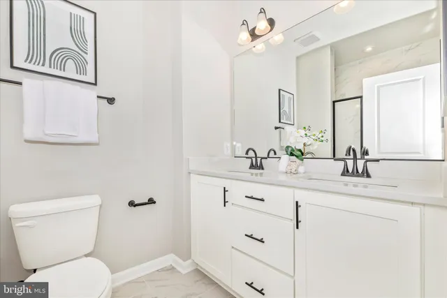 a bathroom with a toilet a sink and mirror