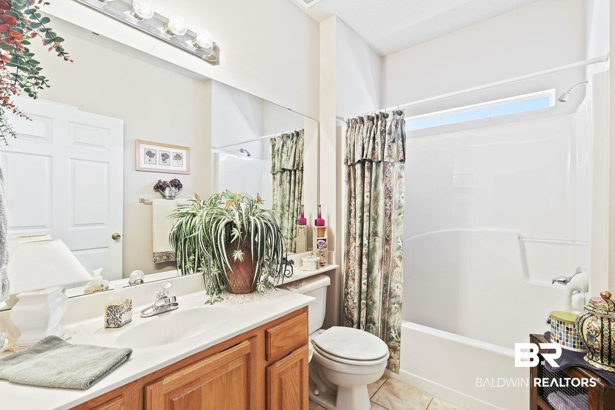 24130 Cowling Road Robertsdale, AL 36567 - Photo 40 of 71 Full bathroom featuring tile patterned floors, vanity, shower / bath combination with curtain, and toilet