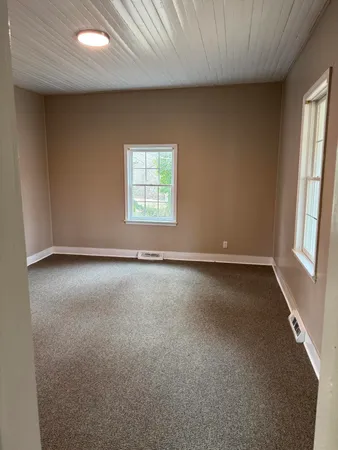 an empty room with a windows and entrance