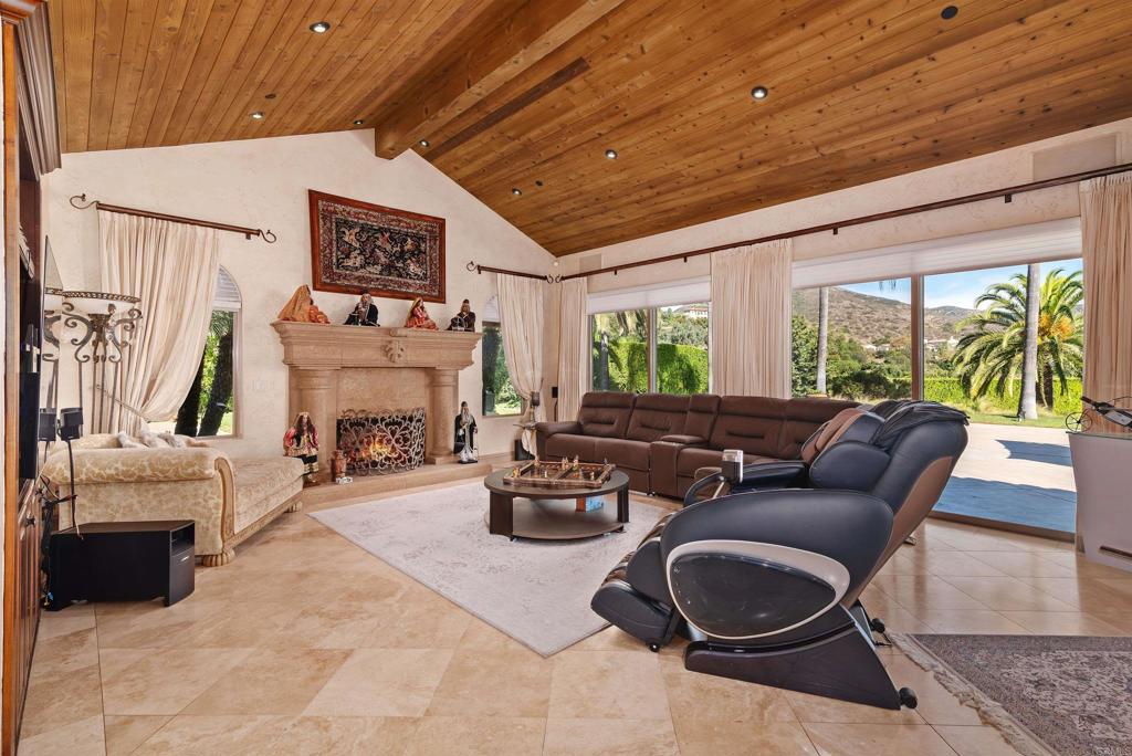 18545 Aliso Canyon Road Rancho Santa Fe, CA 92091 - Photo 12 of 48 a living room with furniture a fireplace and a large window