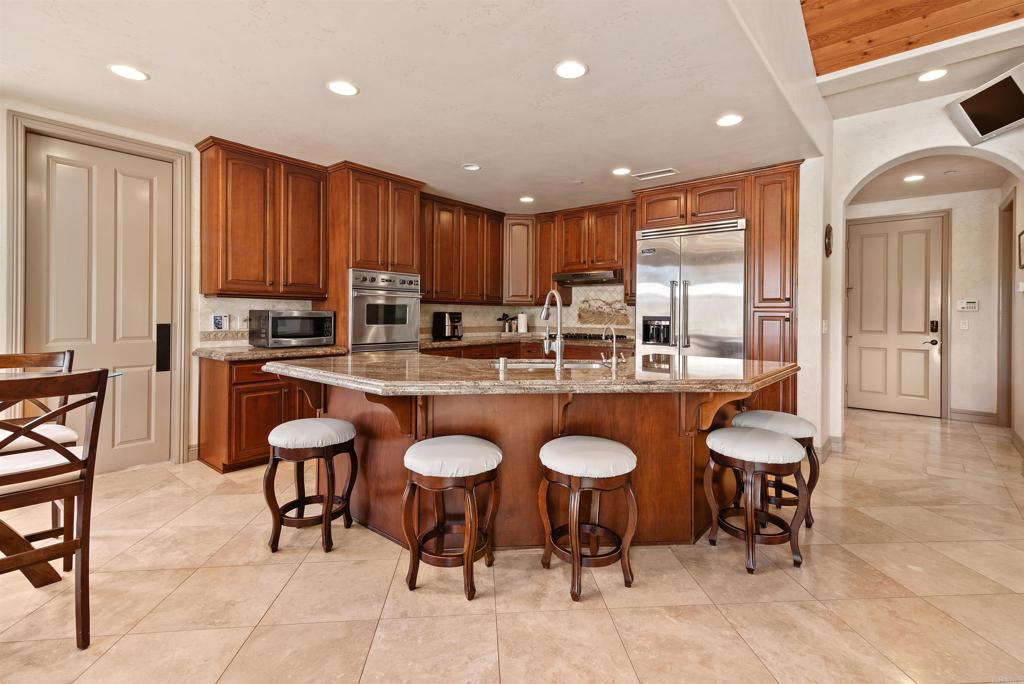 18545 Aliso Canyon Road Rancho Santa Fe, CA 92091 - Photo 16 of 48 a kitchen with a dining table chairs and large window