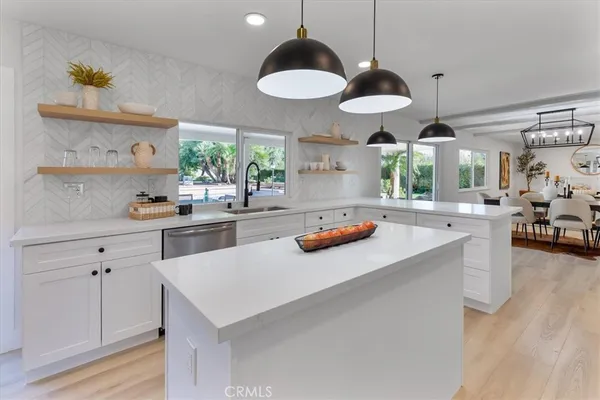 a kitchen with stainless steel appliances a stove a sink a chimney and a center island
