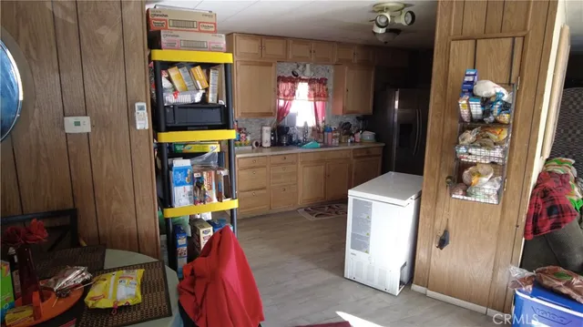 a kitchen with stainless steel appliances a stove a refrigerator a sink dishwasher and wooden cabinets with wooden floor