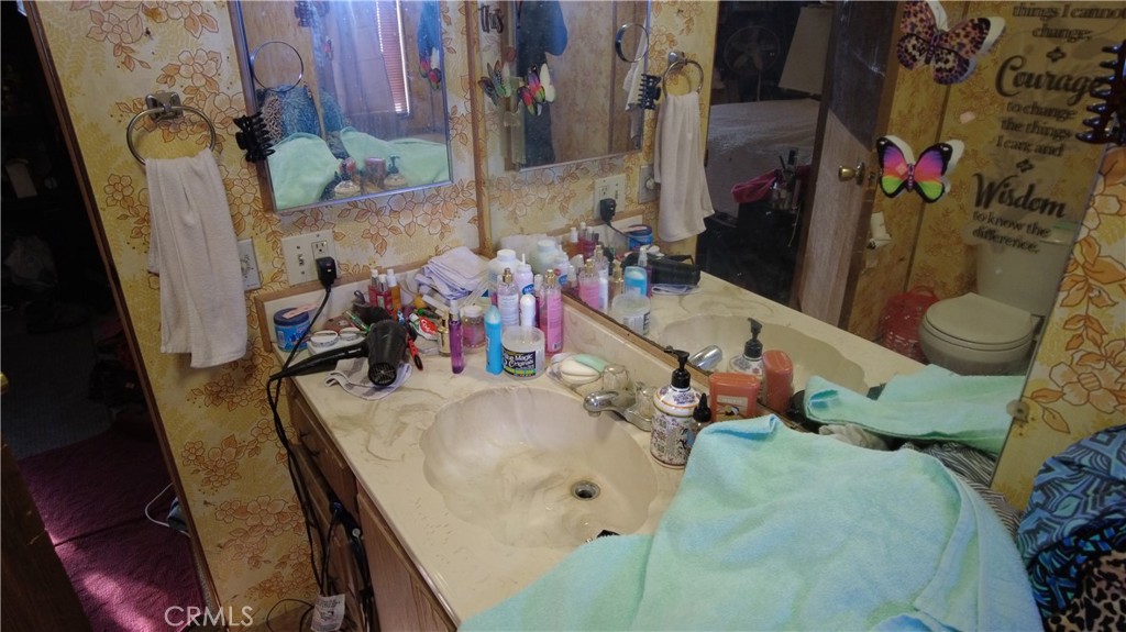 4561 Adobe Road, Unit 1 Twentynine Palms, CA 92277 - Photo 47 of 57 a bathroom with a sink mirror and toilet