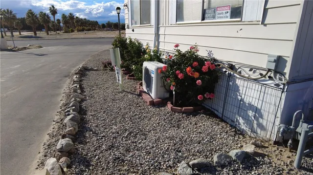a view of a house with a yard and potted plants