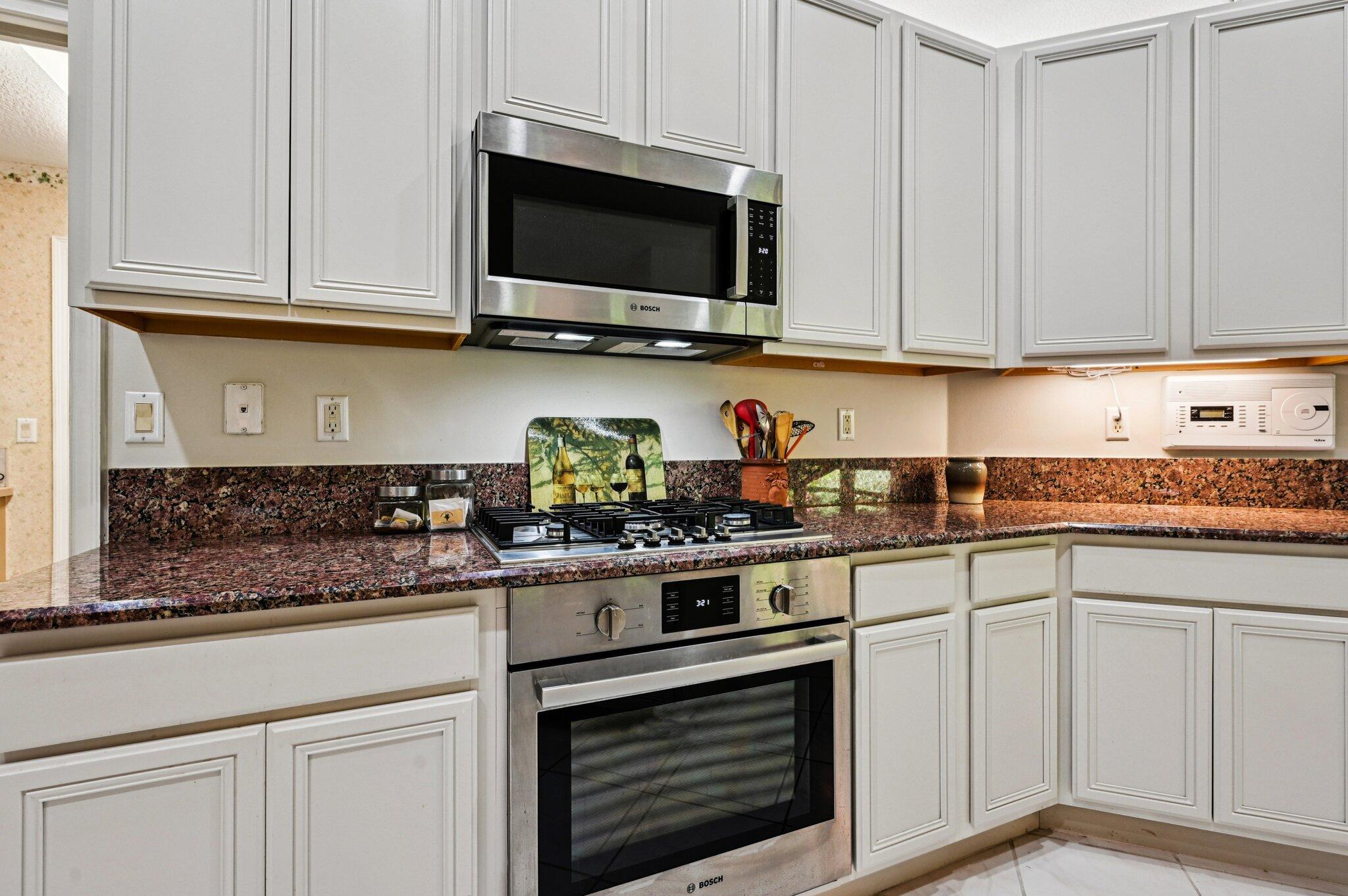 231 Sparrow Point Jupiter, FL 33458 - Photo 16 of 65 a kitchen with white cabinets and appliances