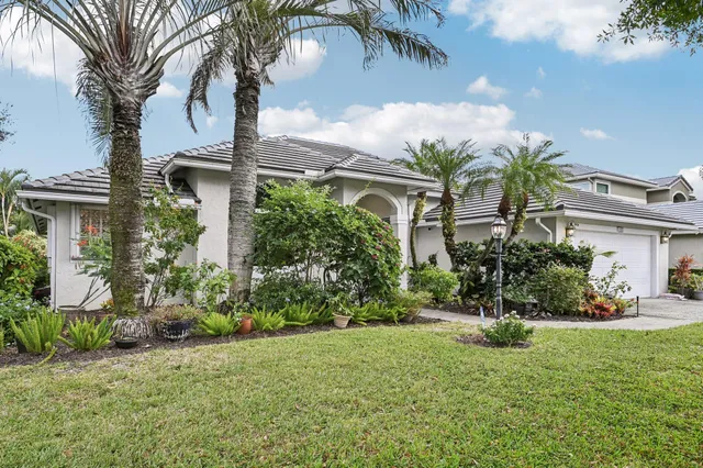 a view of a house with a big yard and large trees